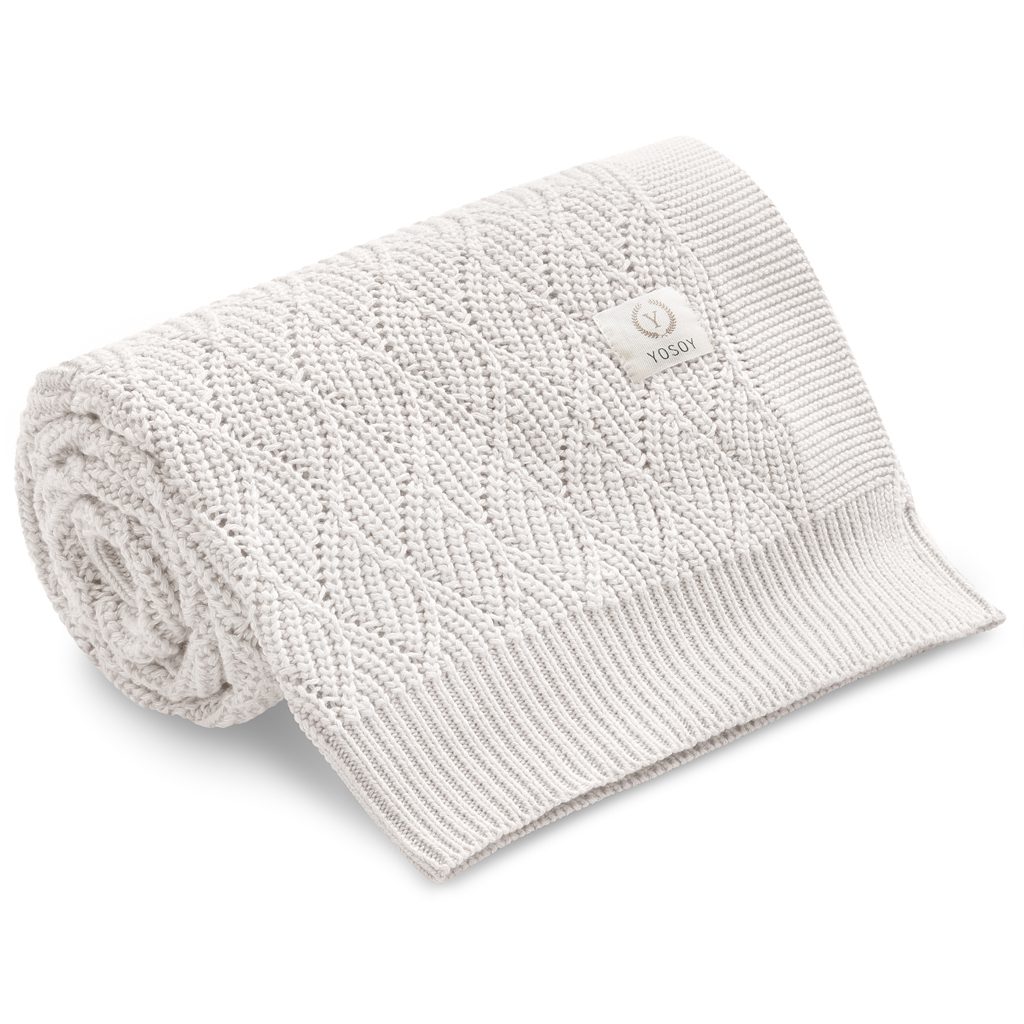 Biała kocyk niemowlęcy z dzianiny z delikatnym wzorem, idealny na chłodne dni.