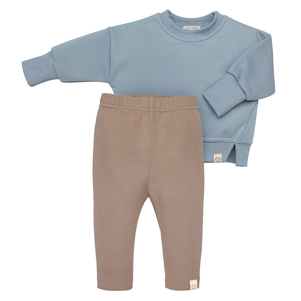 Bluza dziecięca w kolorze niebieskim i spodnie w kolorze beżowym.