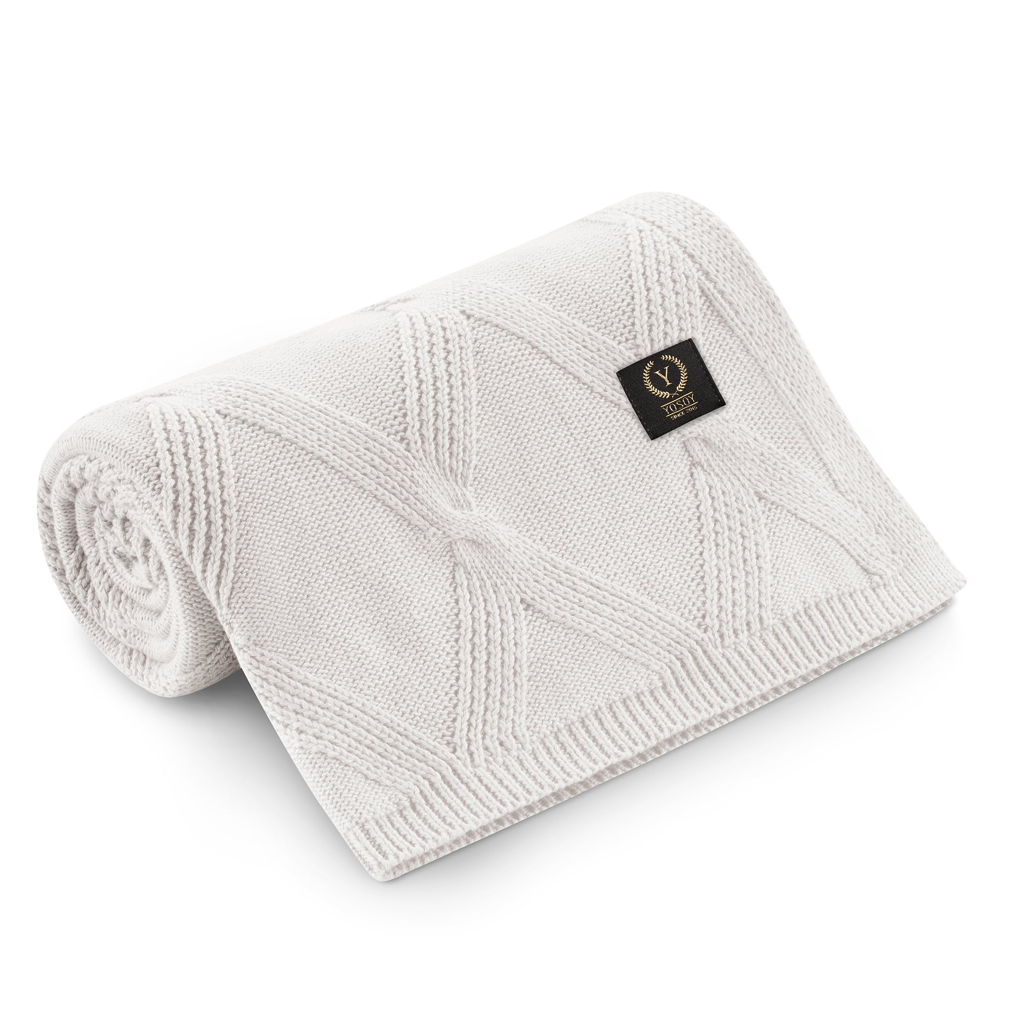 Kremowy kocyk dla niemowląt z delikatnym wzorem i etykietą.