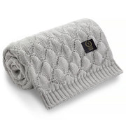 Szary kocyk dziecięcy z dzianiny o plecionym wzorze z metką marki.