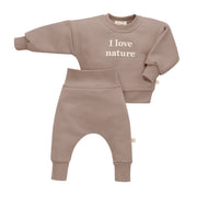 Dwuczęściowy zestaw ubranek dla niemowląt w beżowym kolorze, bluza z napisem "I love nature" i spodnie.
