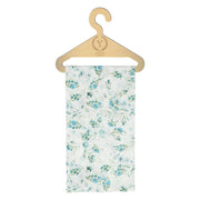 Dziecięca chusta z niebieskim kwiatowym wzorem na wieszaku.