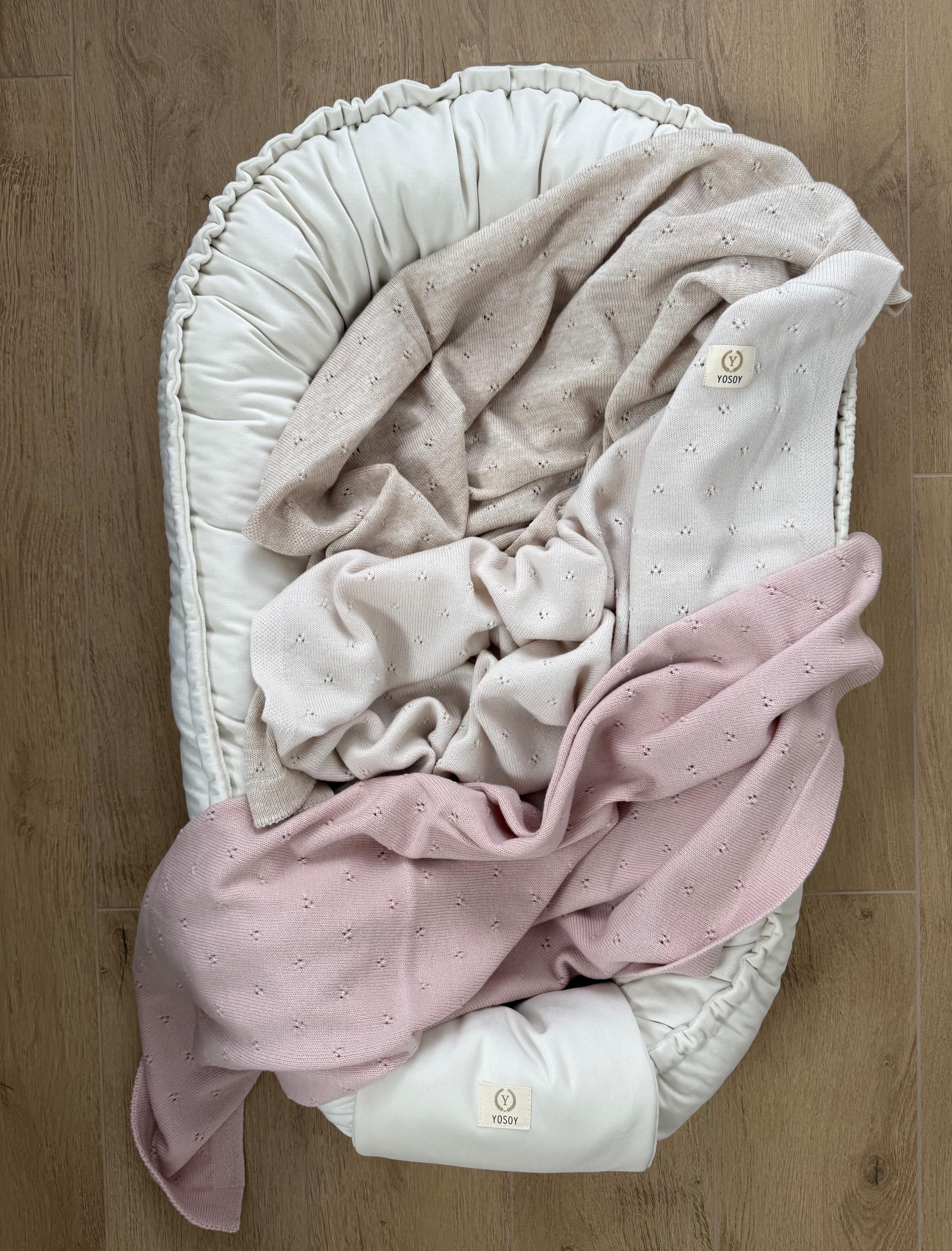 Zbliżenie na koce z wełny merino jersey YOSOY ułożone w kokonie niemowlęcym miękka dzianina i naturalna wełna